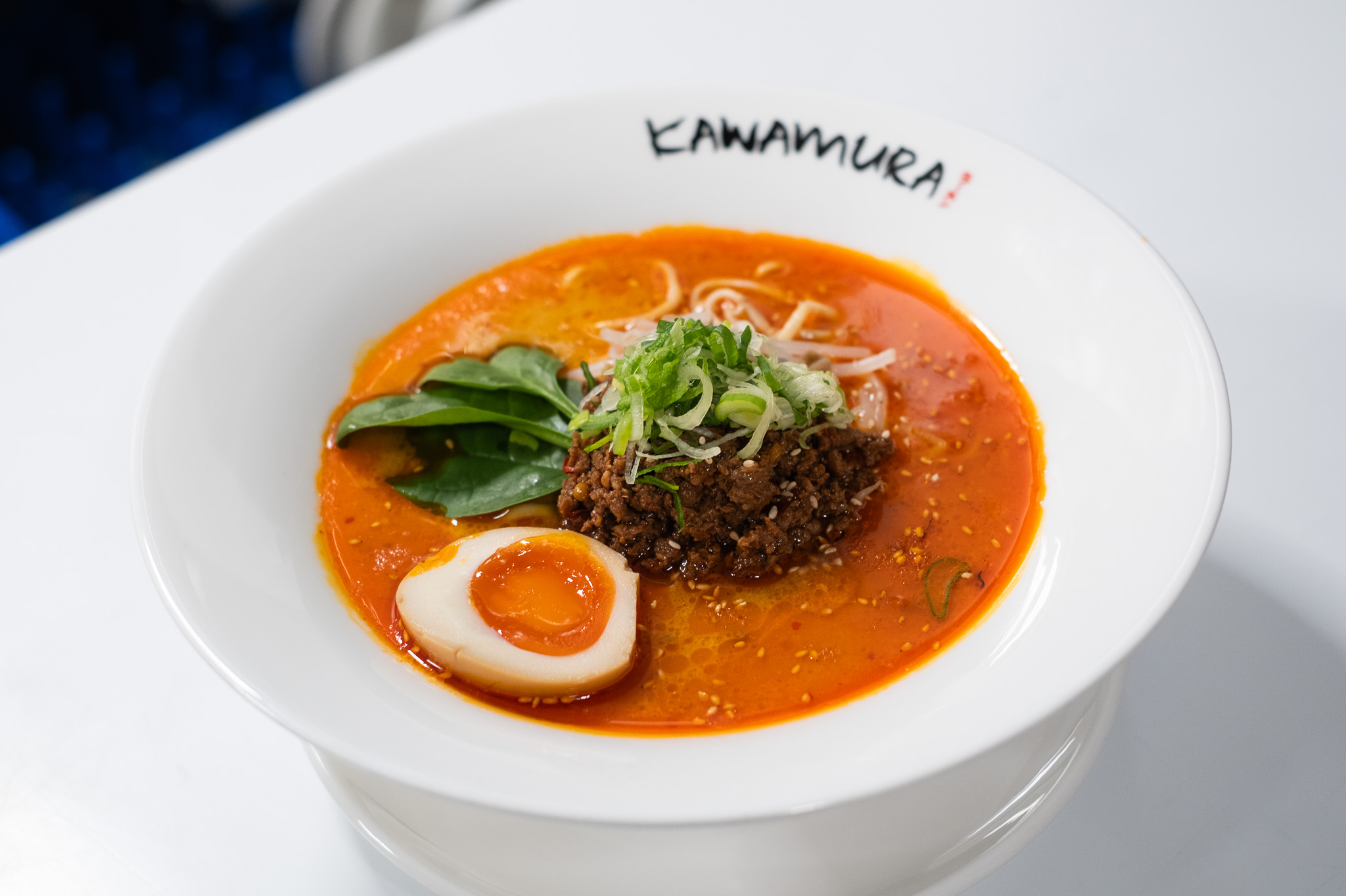 Spicy tantanmen ramen with spiced ground meat, soft-boiled egg, and greens at Kawamura Ramen Budapest